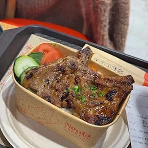Grilled lemongrass pork chop rice plate, cơm sườn nướng, with tomato and cucumber at Nón Lá Express
