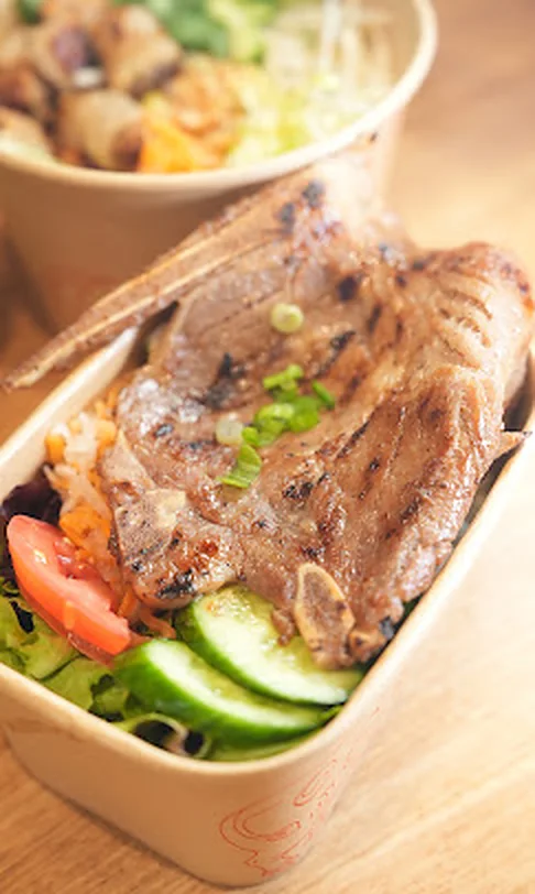 Grilled lemongrass ribeye rice plate with cucumber and tomato from Nón Lá Express Flushing