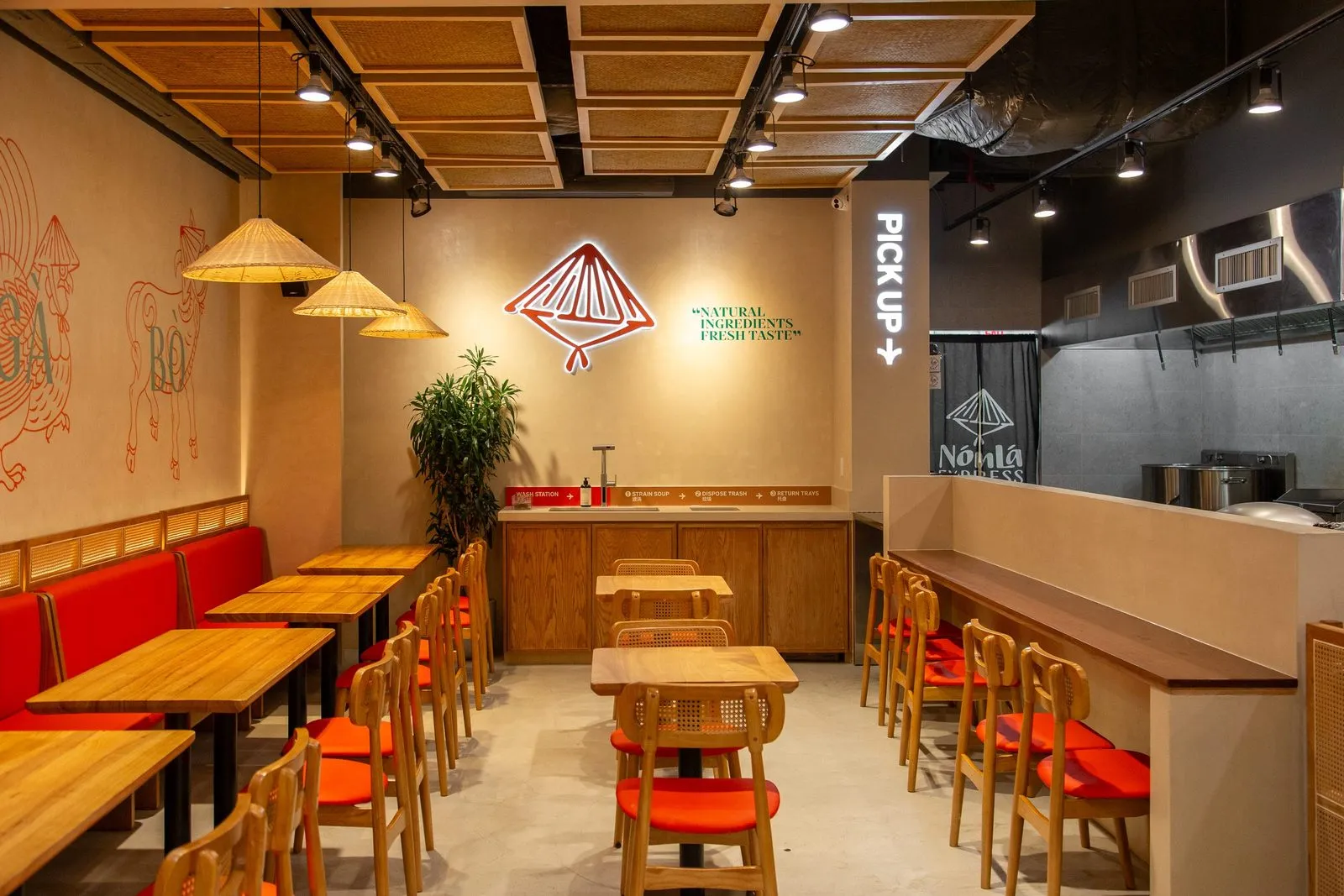 Nón Lá Express dining room at Tangram Food Hall in Flushing with nón lá conical-hat pendant lamps and red banquette seating