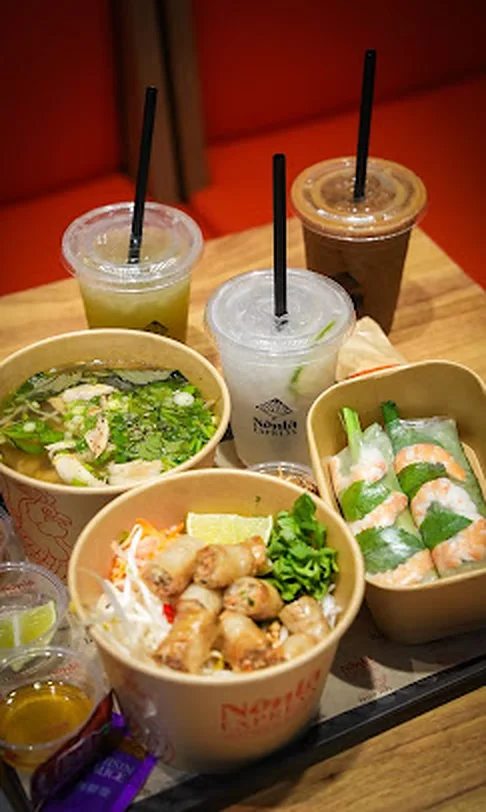Phở, summer rolls and iced drinks shared at a table at Nón Lá Express, Flushing