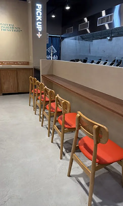 Pickup counter and window seating at the Nón Lá Express stall in Tangram Food Hall