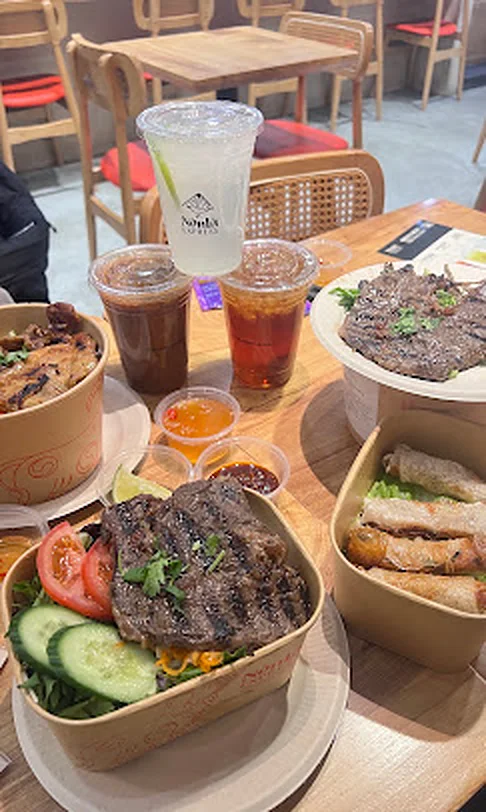 Vietnamese rice plates, spring rolls and iced drinks spread on a table at Tangram, Flushing